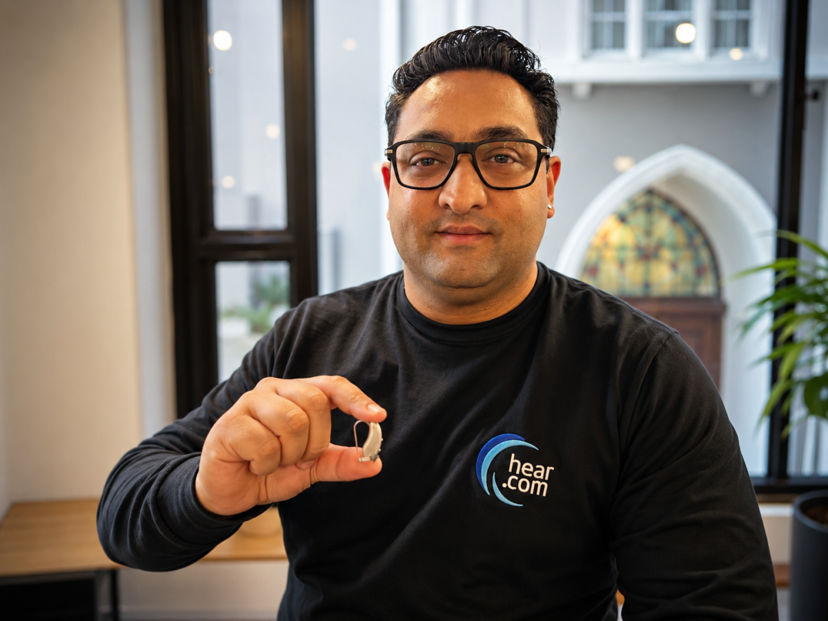 Man holding small hearing aid
